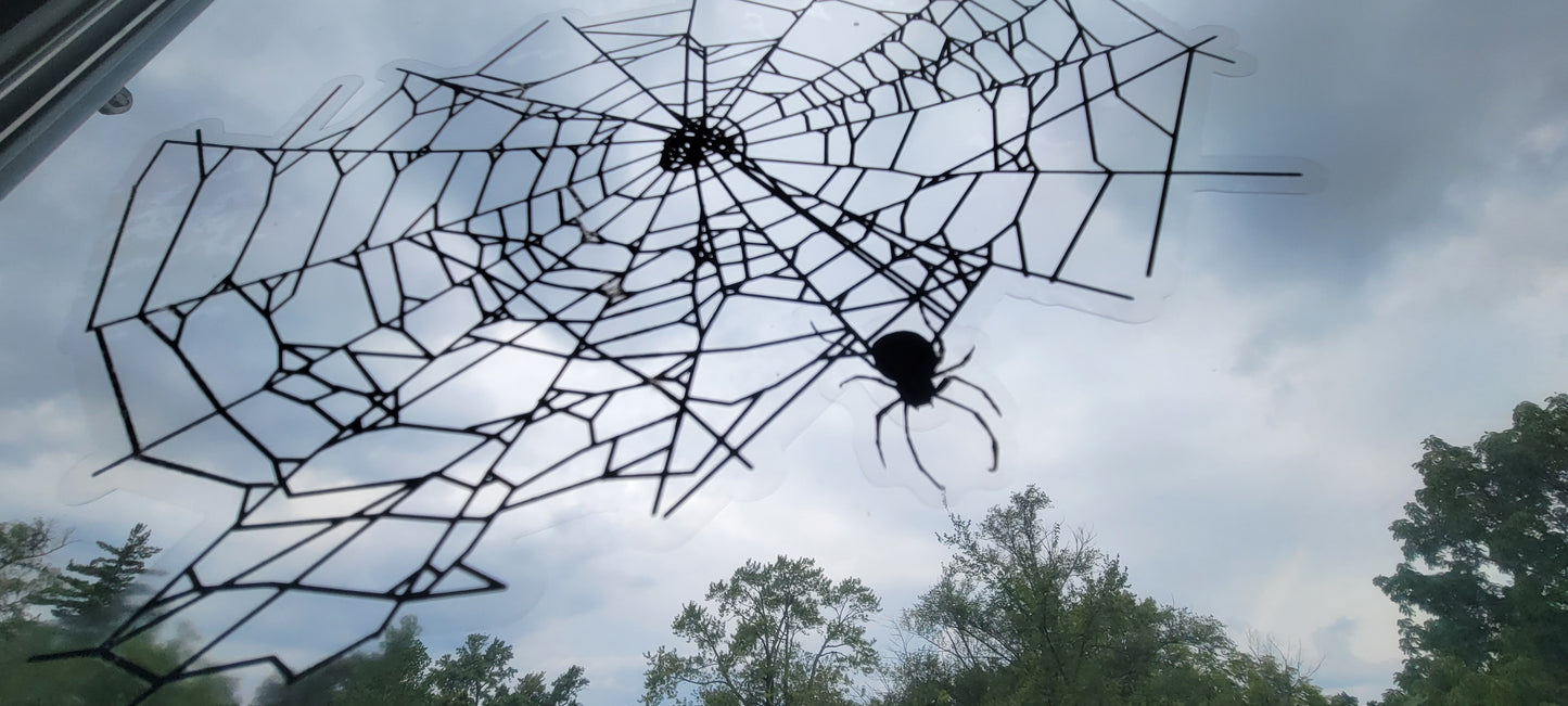 A close up photo of a spider web and spider from our static cling window decor set.