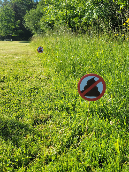 a photo of multiple no pooping yard signs (round, 6 inch diameter) in a row, marking the perimeter of a property.