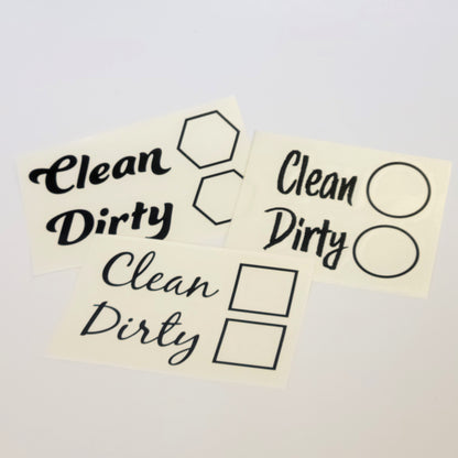The InkBird Print Studio LLC Clean/Dirty Dishwasher Vinyl Cut Decal serves as a clever chore reminder with stickers featuring the words "Clean" and "Dirty" in various fonts. Accompanying these words are dishwasher decal icons such as hexagons, circles, and squares, all crafted from durable vinyl with permanent adhesive for lasting use.