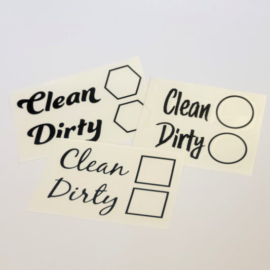 The InkBird Print Studio LLC Clean/Dirty Dishwasher Vinyl Cut Decal serves as a clever chore reminder with stickers featuring the words "Clean" and "Dirty" in various fonts. Accompanying these words are dishwasher decal icons such as hexagons, circles, and squares, all crafted from durable vinyl with permanent adhesive for lasting use.