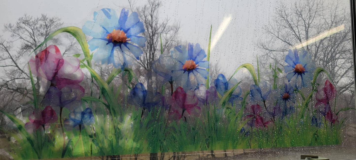 decorative floral design of a meadow, static cling, applied to a rainy window. Blues and pinks, stained glass or watercolor vibes
trees can be seen through the imagery, blurry but visible