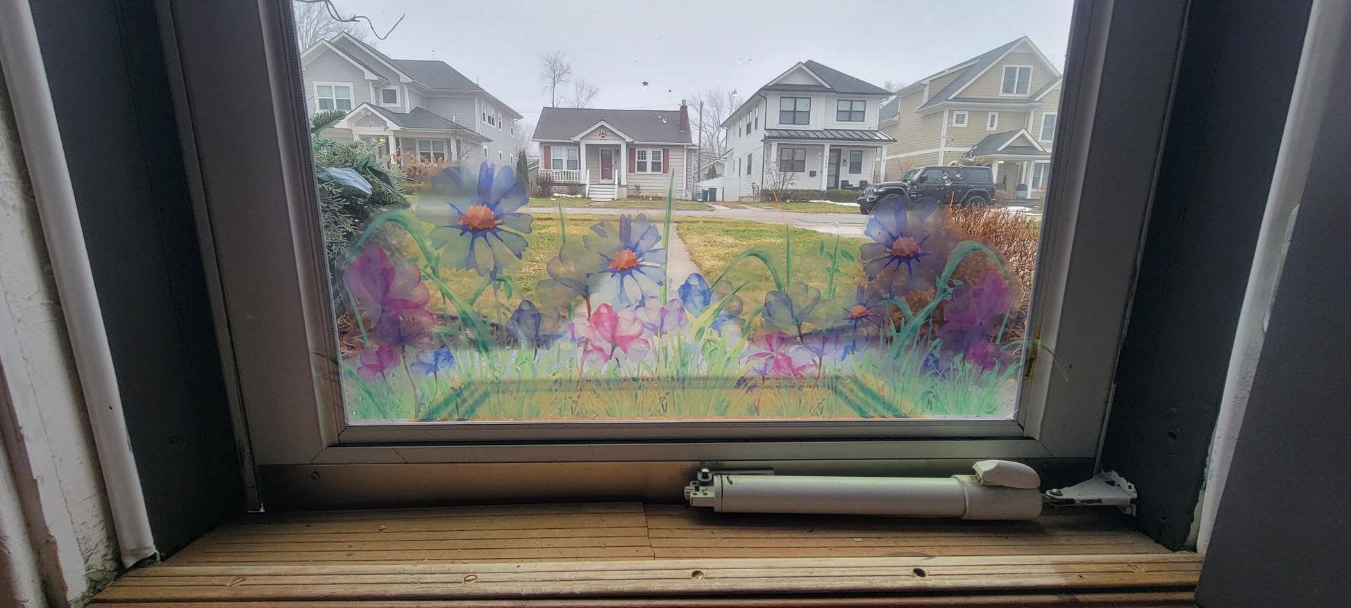 Shown on a storm door.
Decorative floral design of a meadow, static cling
Blues and pinks, stained glass or watercolor vibes