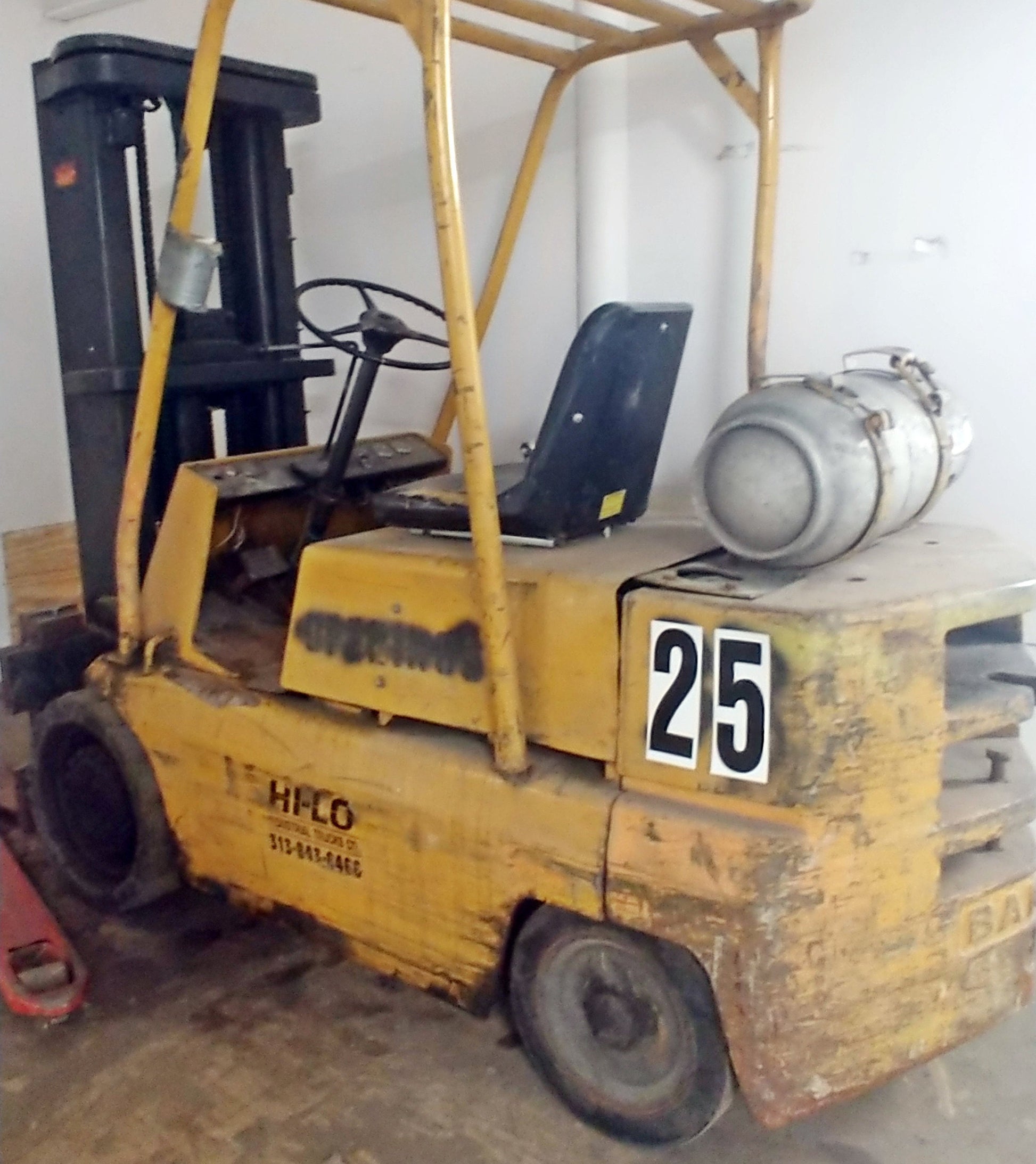 The numbers 2 and 5 printed as 12 inch tall stikons decals, applied to the side of a forklift for warehouse labelling and tracking. 