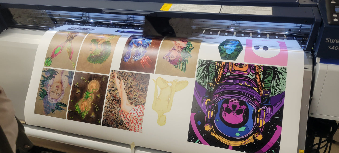 Wide-format vinyl sticker printer producing vibrant, custom astronaut and abstract art on glossy adhesive sheets, poster-size output.