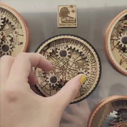A short video showing a hand spinning a set of planetary gears, which align to show a roadmap of Pontiac, MI