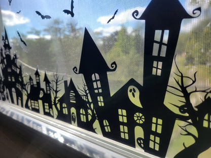 A closeup shot of part of our Our Spooky Town Halloween static cling window decoration. Black ink on a clear material, applied to a window with a sunny exterior seen in the background.