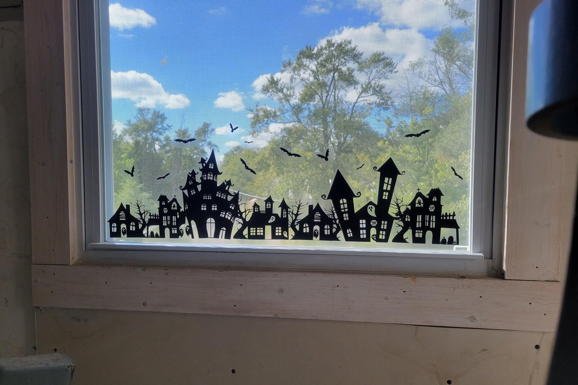 Spooky Static Cling set by InkBird Print Studio. Black ink on clear static material shown on a window with a sunny exterior shown behind it. Showcases the opaque nature of the ink.