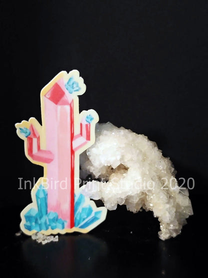 The Crystal Cactus Decal/Sticker, featuring a pink crystal with blue accents next to a cluster of translucent white crystals, stands out vividly against the black background. Perfect for laptops, gifts, water bottles, mirrors, lockers, and more. Text on the image states InkBird Print Studio LLC, 2020.