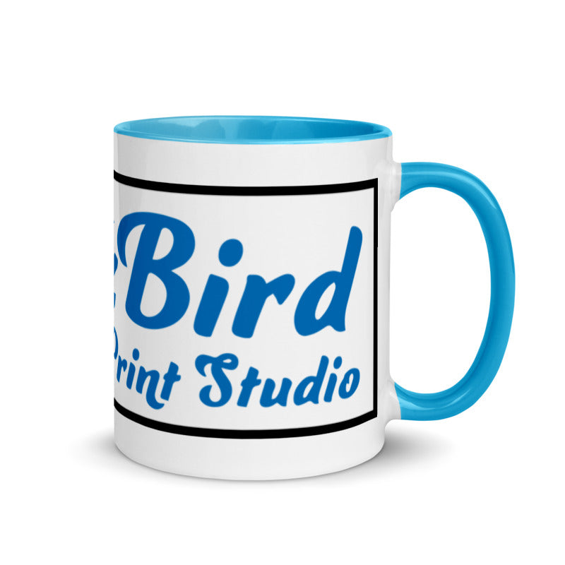 The InkBird Print Studio Logo Mug with Color Inside, from InkBird Print Studio LLC, is a white ceramic mug featuring a blue interior and handle. It displays the words "Bird Print Studio" in blue text surrounded by a black border. This vibrant design is dishwasher safe, combining style with practicality for everyday use.